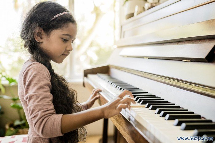 Side view of girl playing piano. Cute female child is practicing on musical instrument. She is at home.